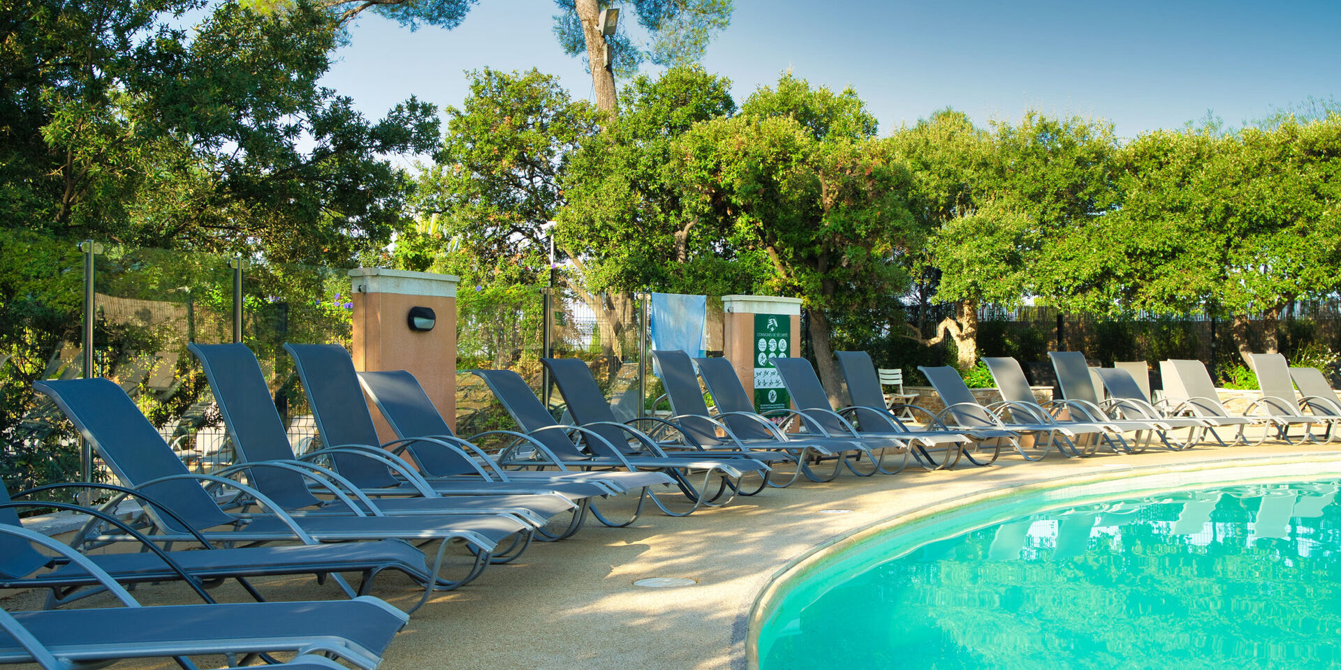 Transats en bord de piscine côté ombre